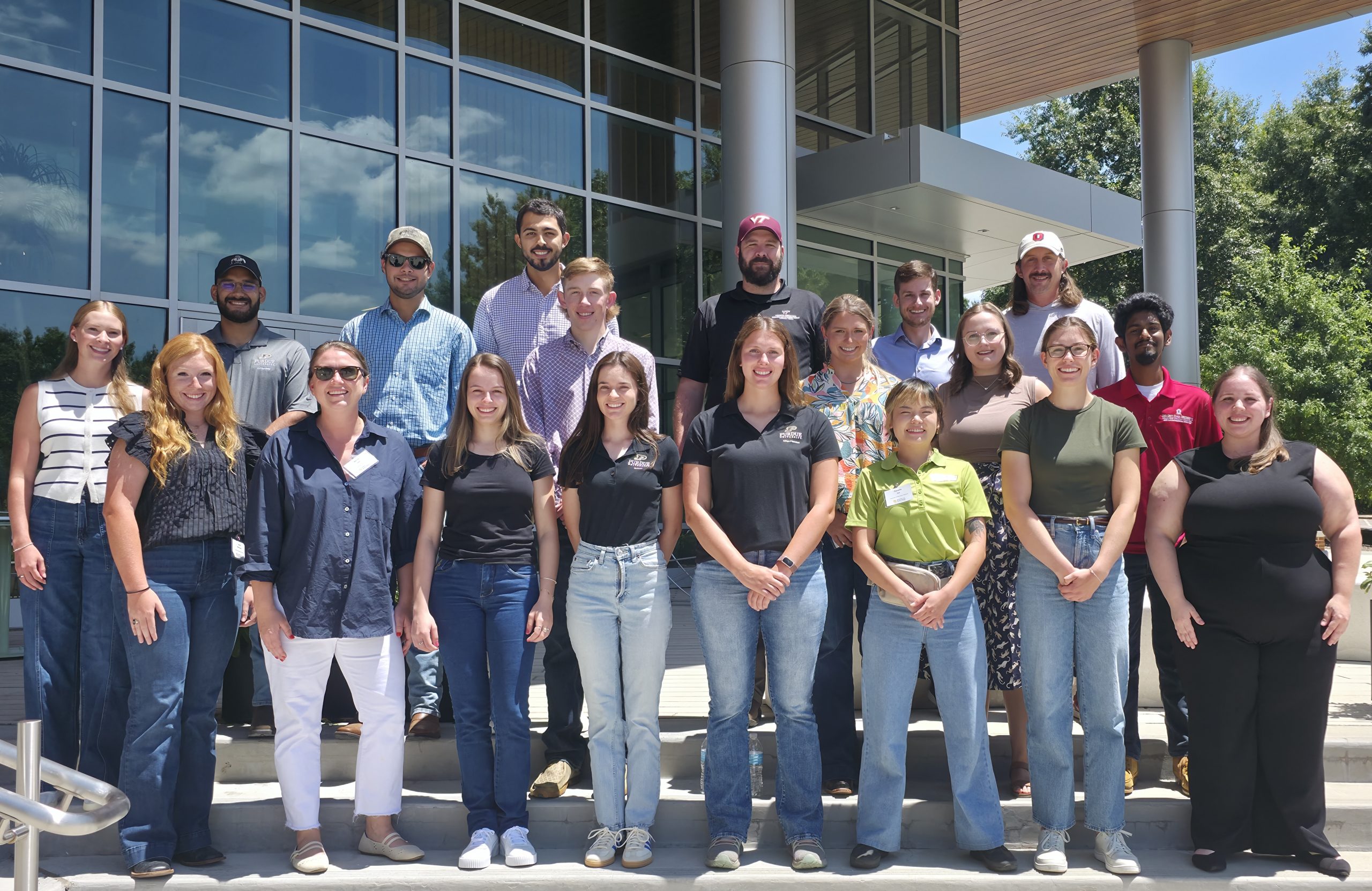 A group of people stand in front of a building for a posed photo.
