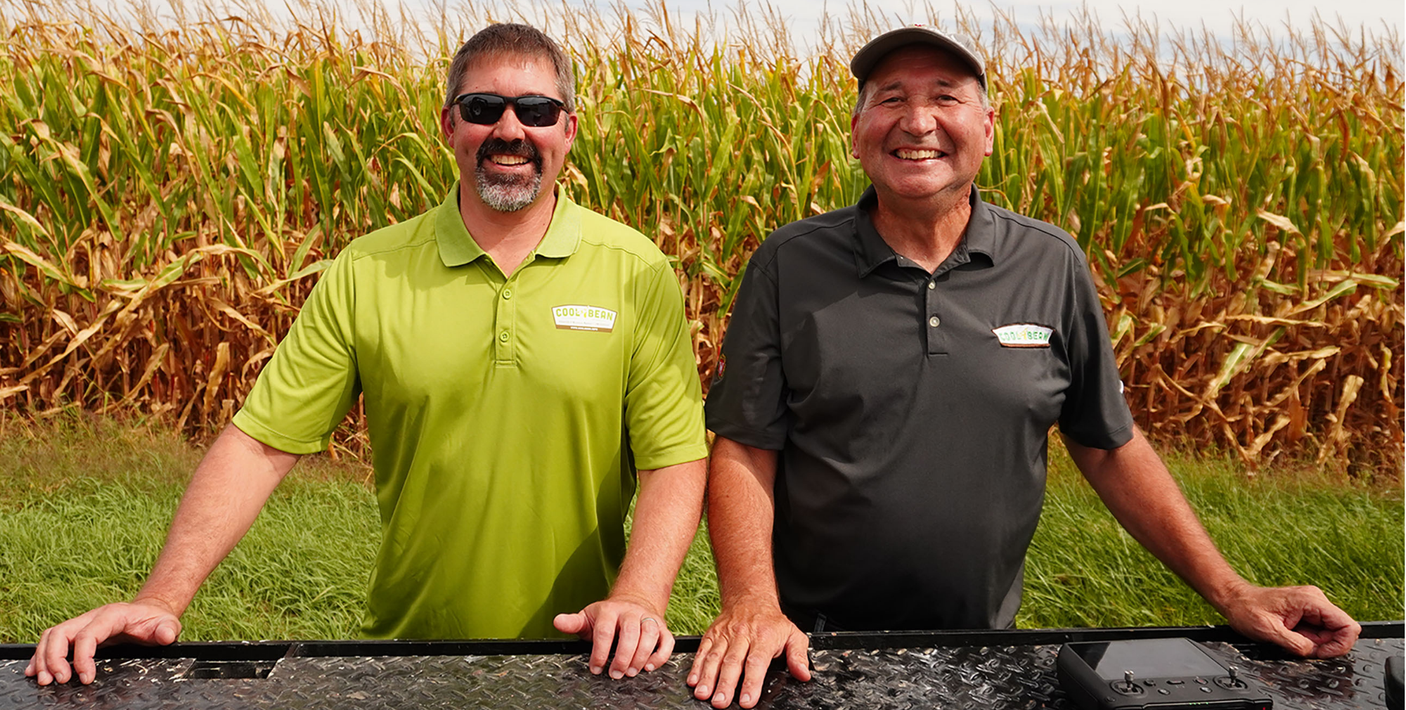 A picture of an agronomist (Shawn Conley) and a farmer in a wheat field smiling.
