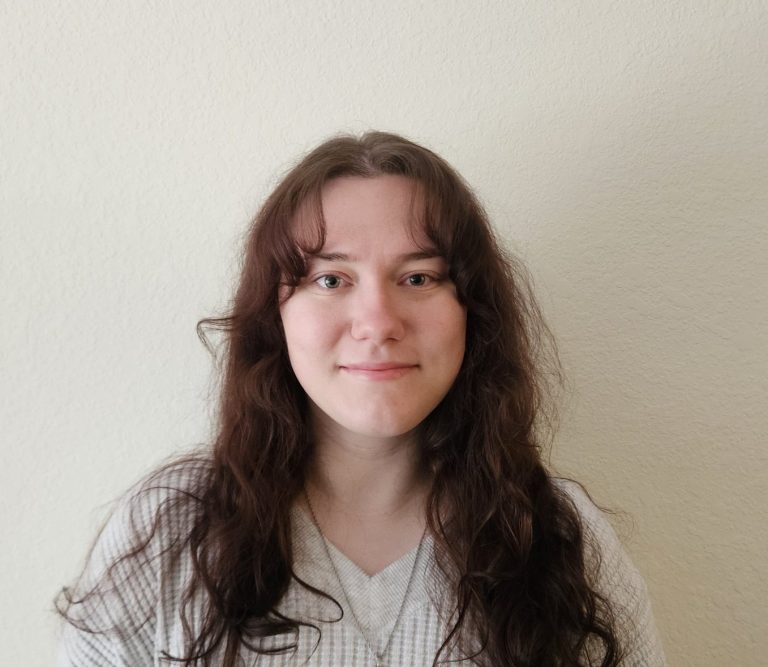A headshot of a young woman with medium length brown hair.